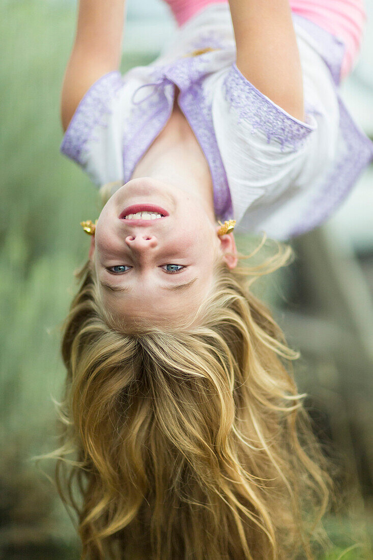 Caucasian girl hanging upside down outdoors, Santa Fe, New Mexico, USA