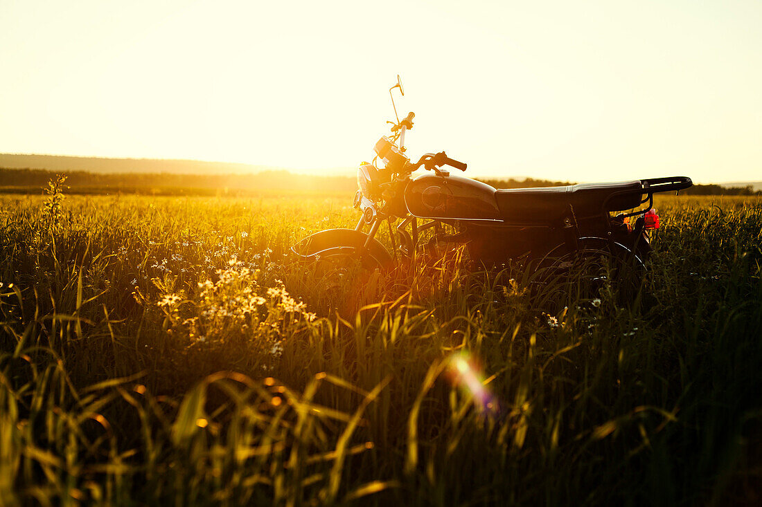 Motorcycle parked in rural field, C1