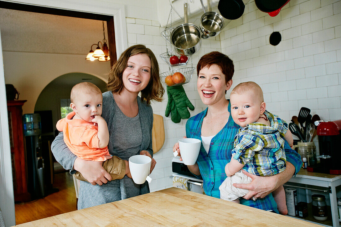 Caucasian mothers holding babies in kitchen, C1