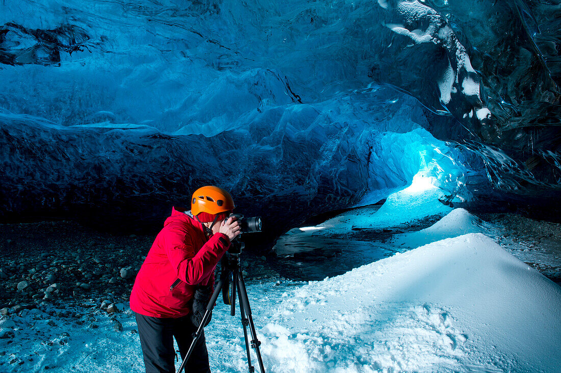 Photographer taking photograph in ice cave, C1