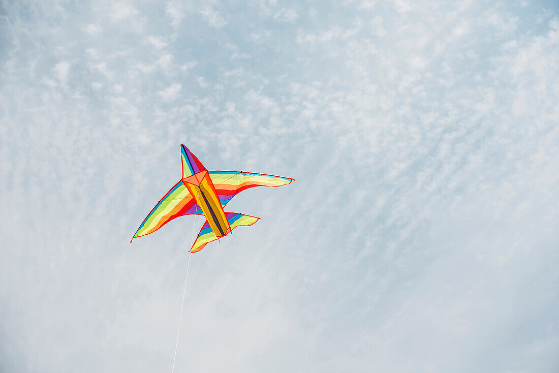 Colorful airplane kite flying in blue sky, C1
