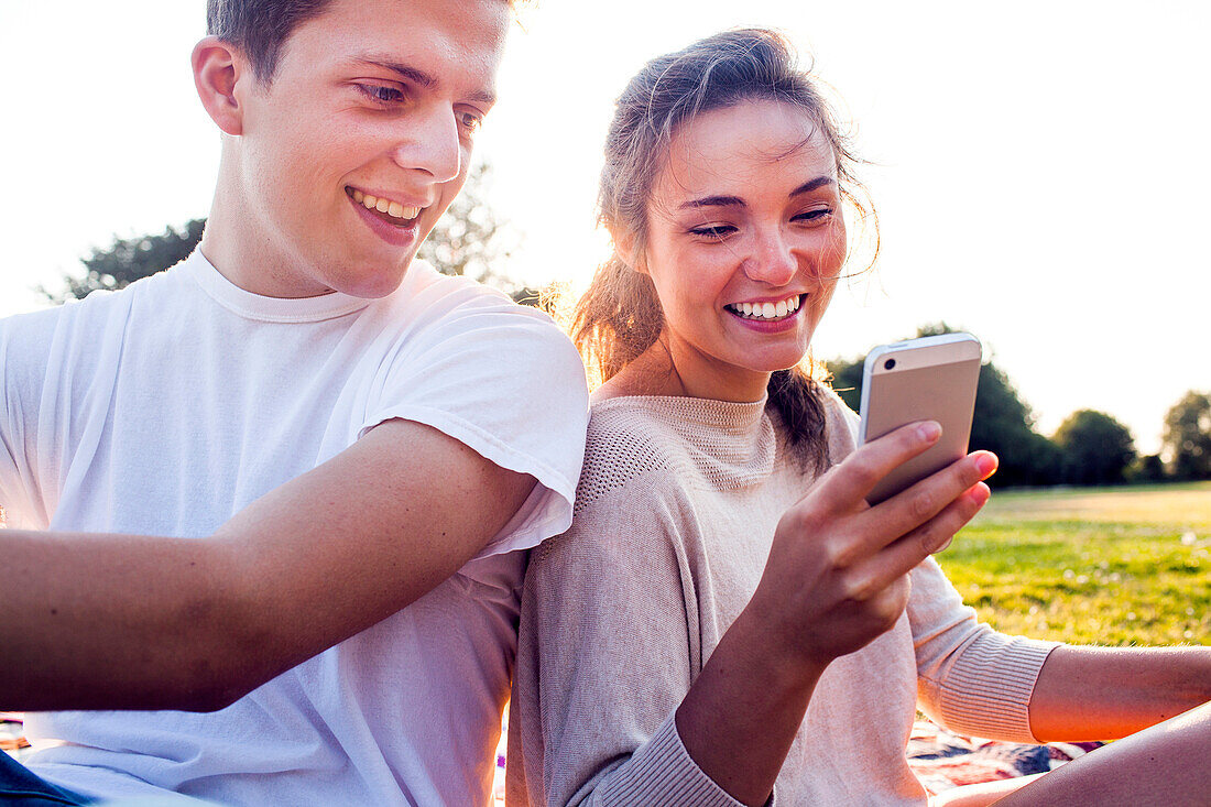 Caucasian couple using cell phone outdoors, Seattle, Washington, United States