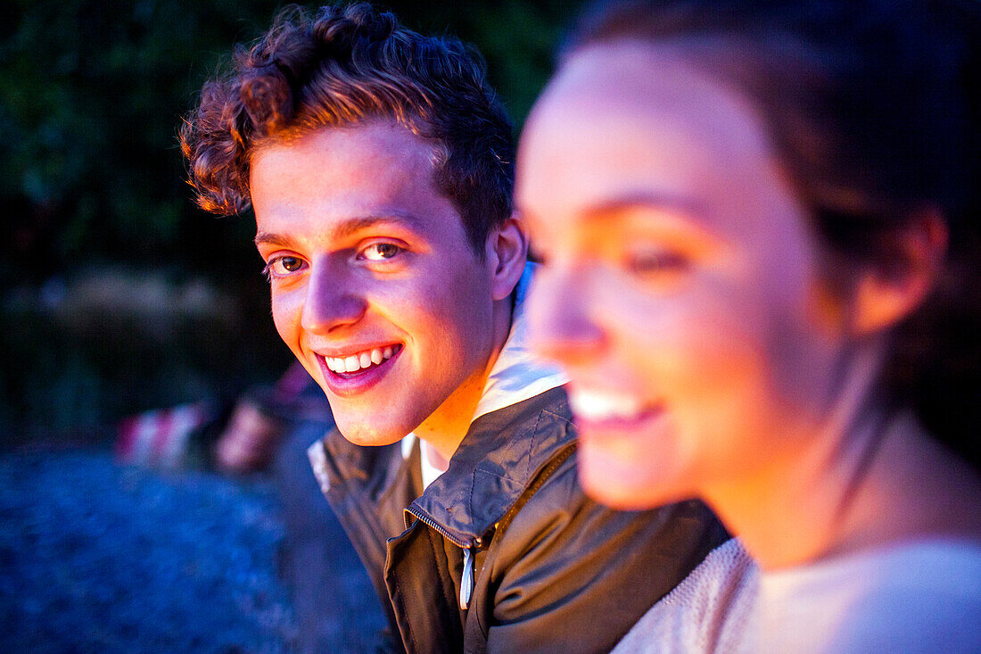 Caucasian couple relaxing together on beach at night, Seattle, Washington, United States