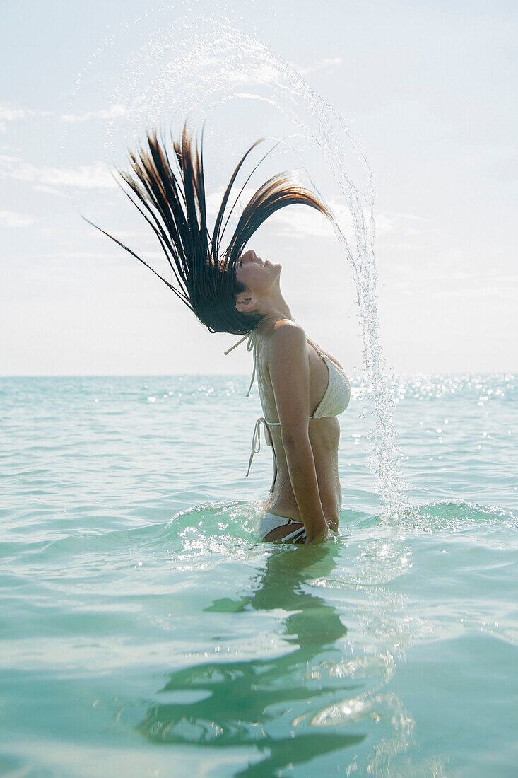 Caucasian woman splashing hair in ocean, Jupiter, Florida, USA