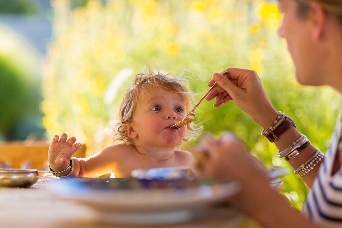 Kaukasische Mutter füttert ihren kleinen Sohn am Tisch, Santa Fe, New Mexico, USA