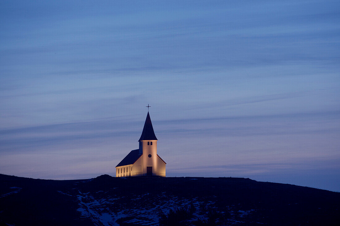White church illuminated in remote landscape, Vik, Sudhurland, iceland