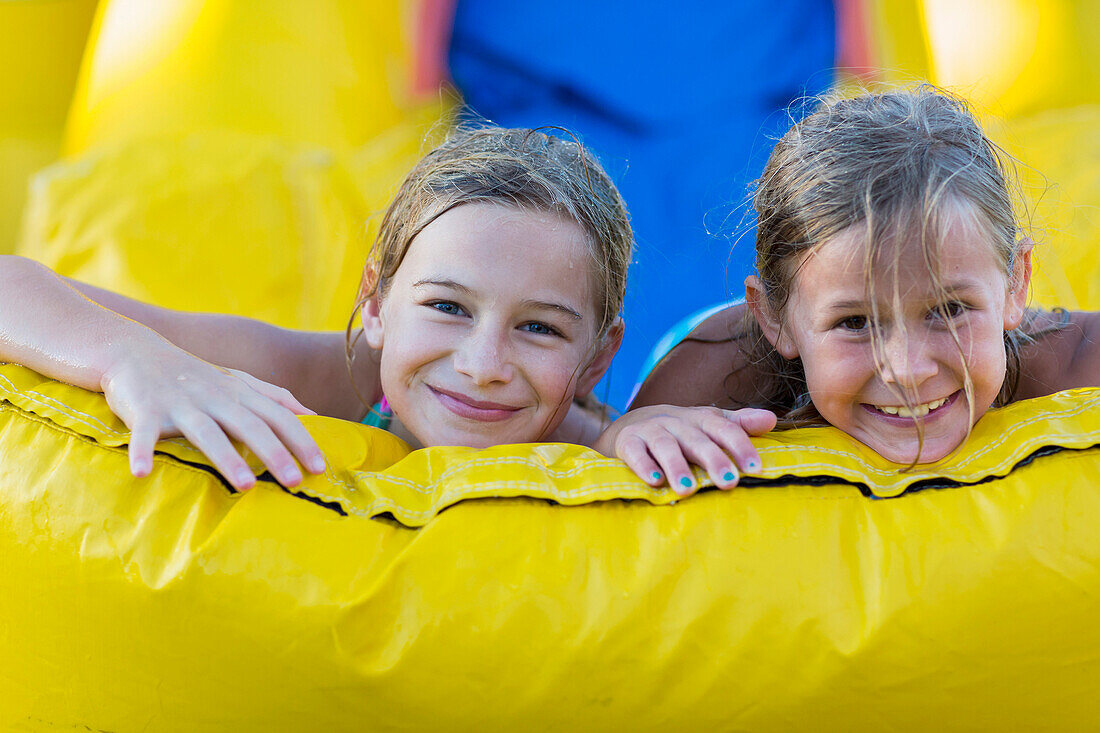 Caucasian girls playing together on inflatable castle, Santa Fe, New Mexico, USA