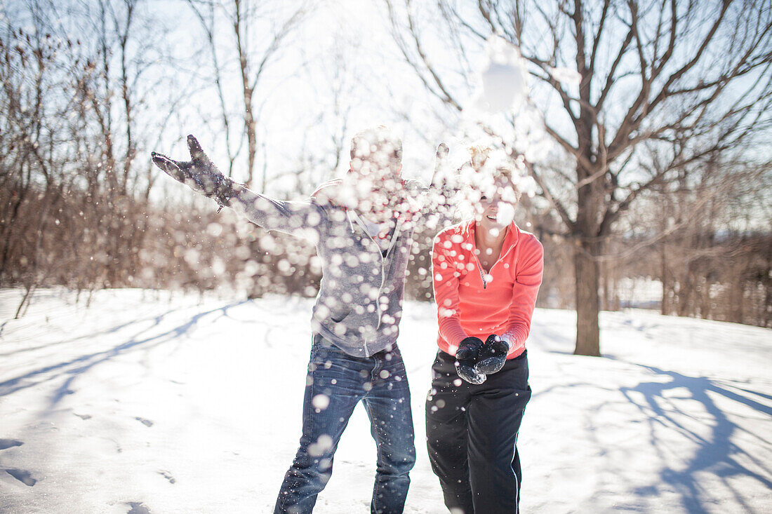 Caucasian couple throwing snowballs, Montreal, Quebec, Canada