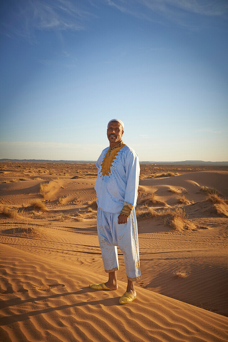 Guide smiling on sand dunes in desert landscape, Sahara Desert, Morocco, Morocco