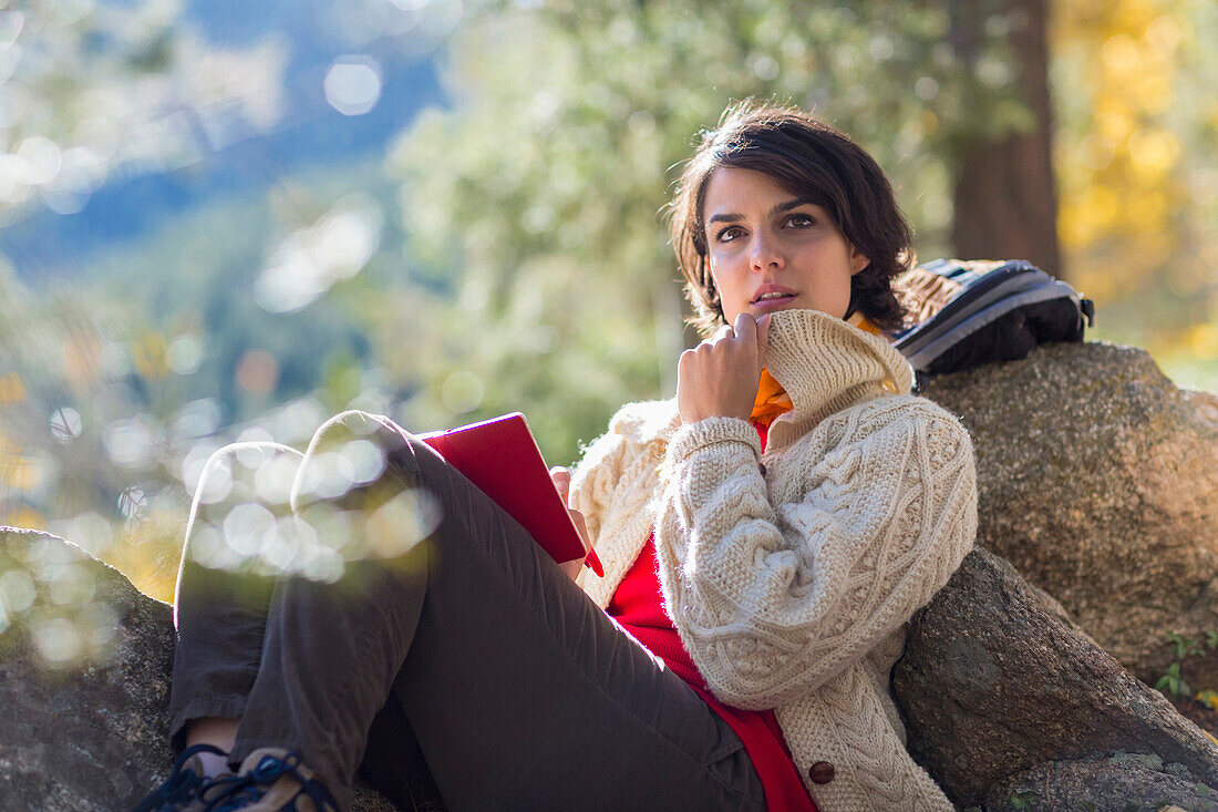 Mixed race hiker reading in forest, Santa Fe, New Mexico, USA