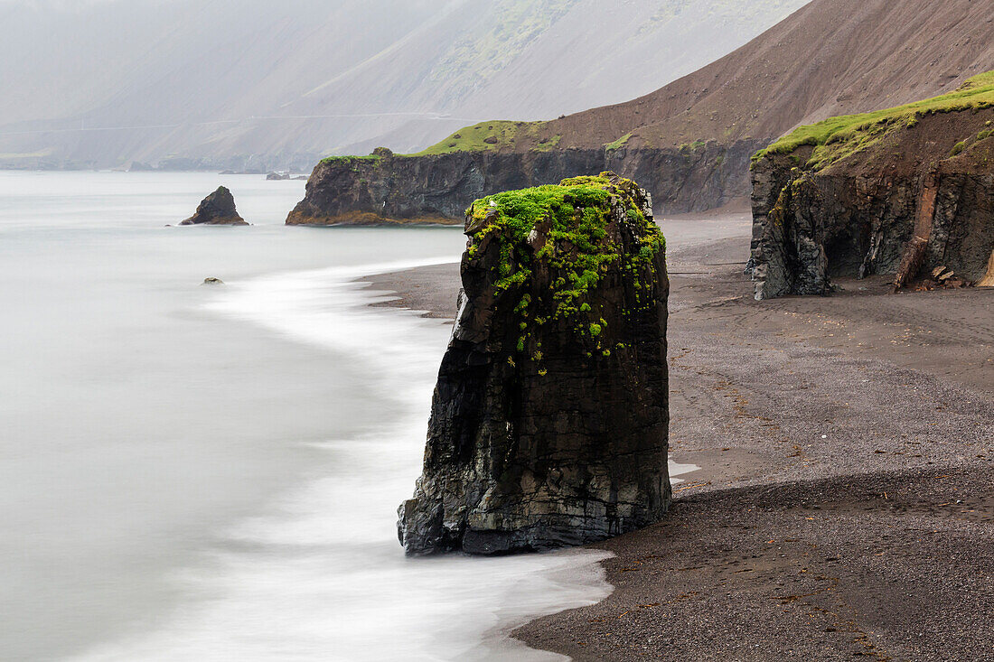 Sea stack rock formations near beach cliffs, Eastern Fjords, Iceland, Iceland