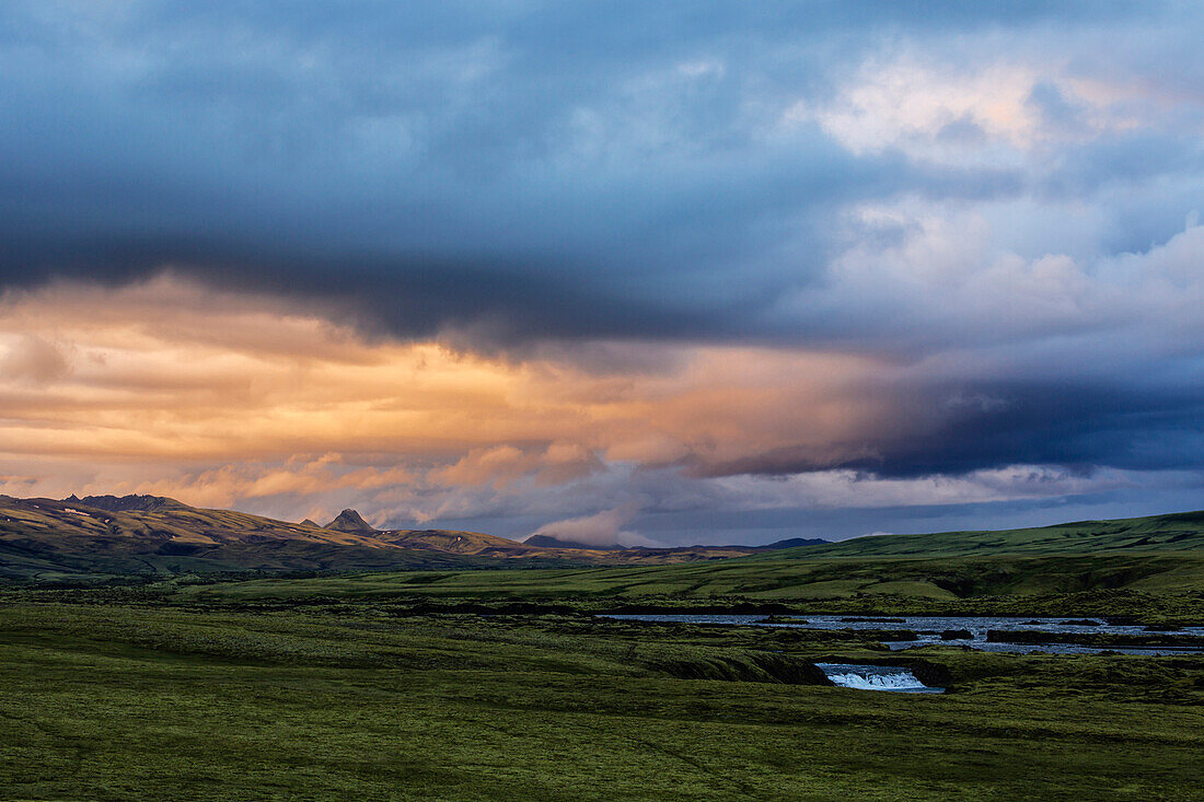 Clouds over green fields in rural landscape, Southern Highlands, Iceland, Iceland