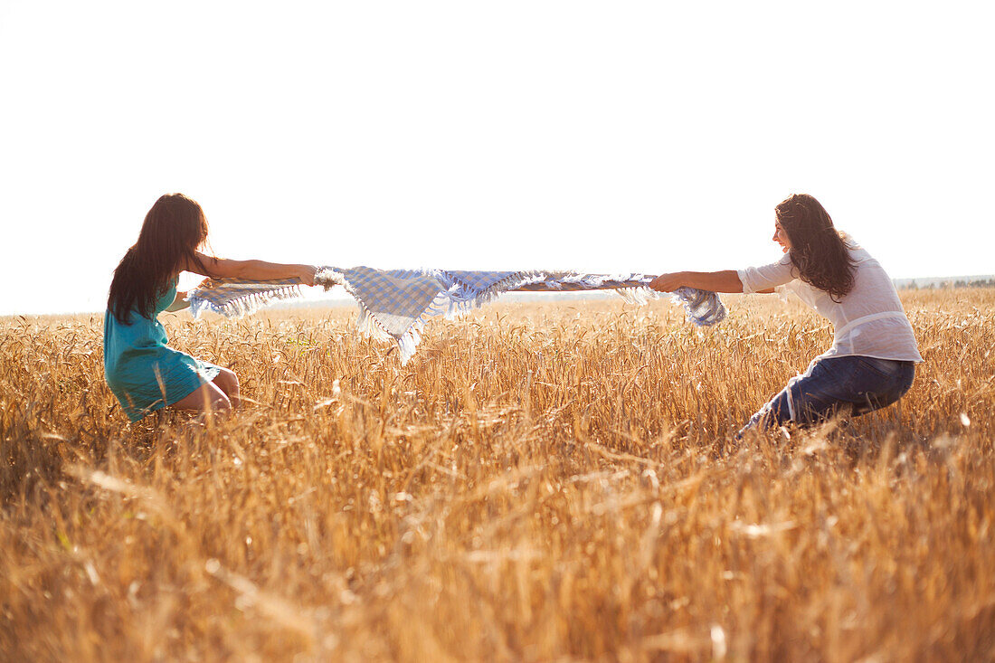 Caucasian women playing tug-of-war in rural field, Nizhniy Tagil, Sverdlovsk region, Russia