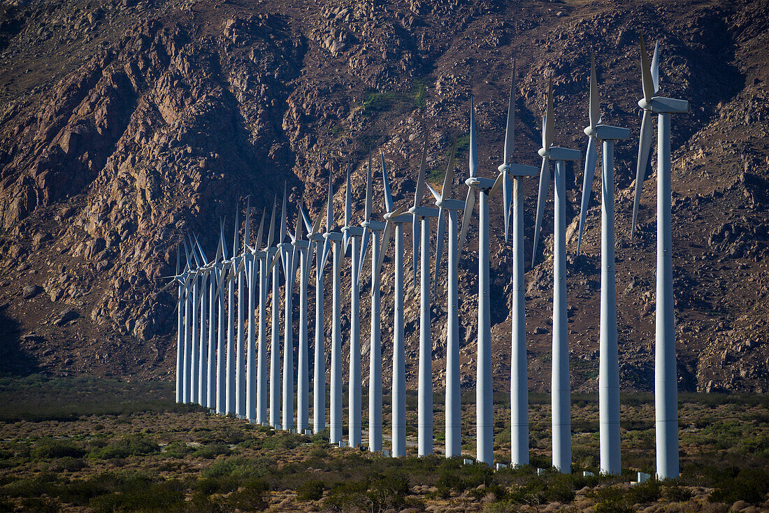 Row of wind turbines in rocky remote landscape, Los Angeles, California, USA