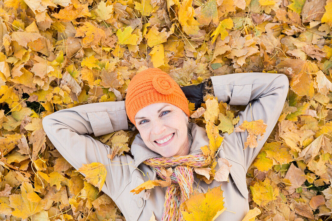 Older Caucasian woman smiling in autumn leaves, Provo, Utah, USA