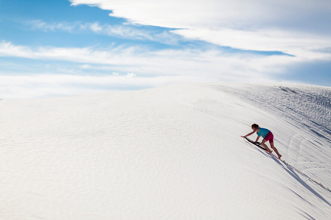 Caucasian girl climbing sand dune, White Sands, New Mexico, USA