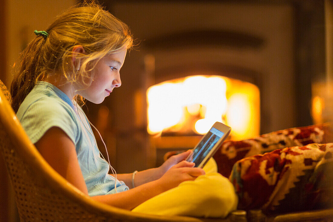 Caucasian girl using digital tablet in living room, Santa Fe, New Mexico, USA