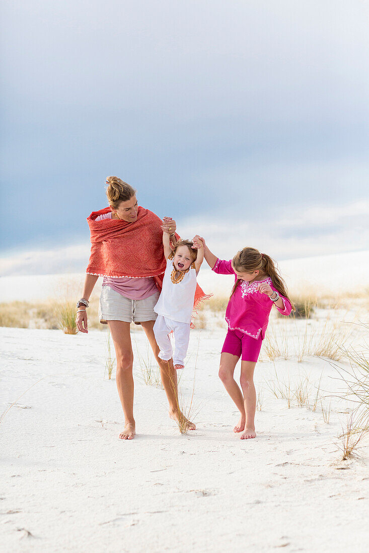 Caucasian mother and children walking on sand dune, White Sands, New Mexico, USA