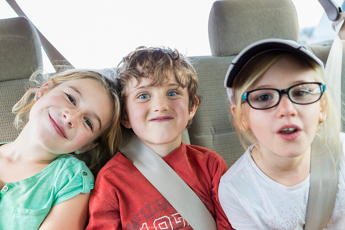 Caucasian children smiling in back seat of car, Santa Fe, New Mexico, USA