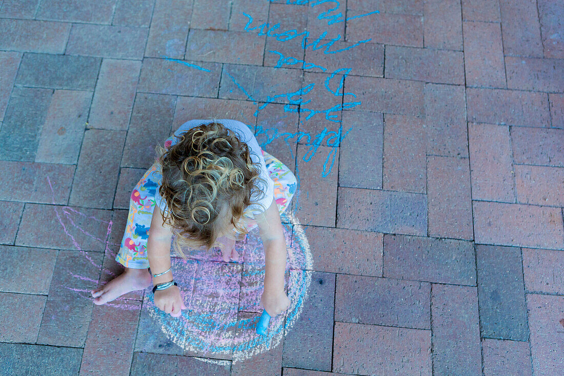 Caucasian boy drawing with chalk on patio, Santa Fe, New Mexico, USA