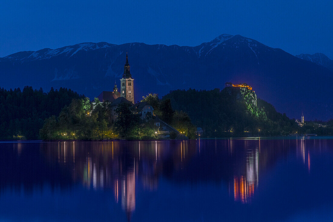 Village church and buildings reflected in still lake at night, Bled, Upper Carniola, Slovenia, Bled, Upper Carniola, Slovenia