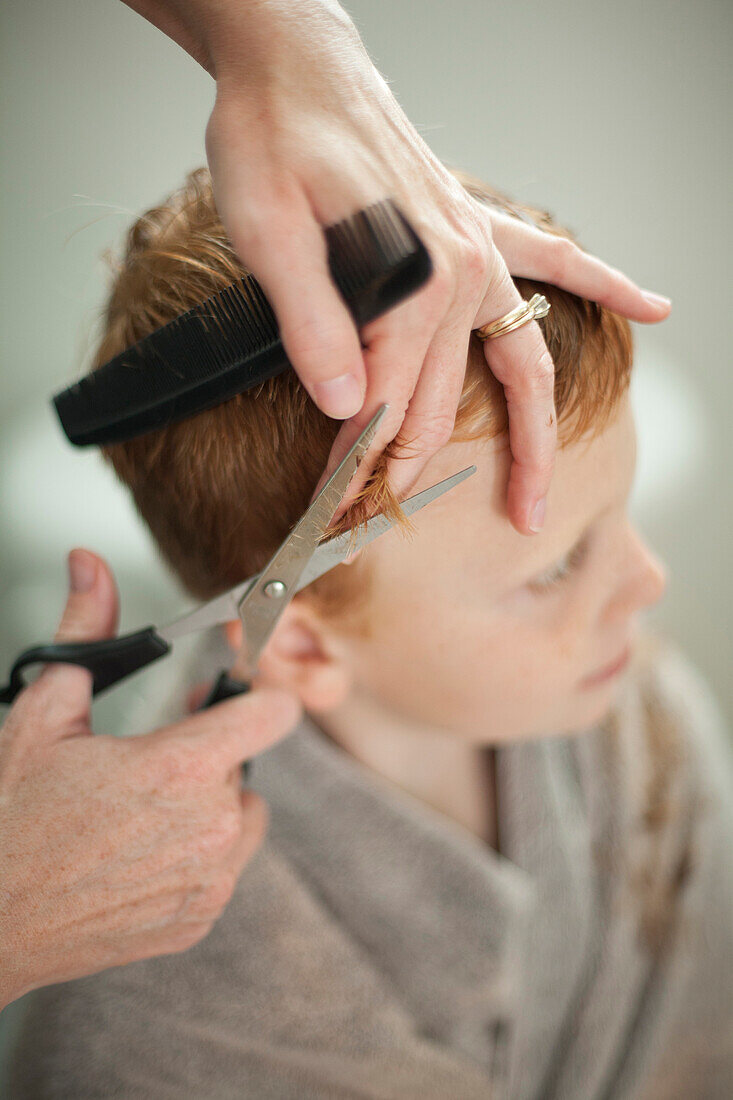 Caucasian mother giving son haircut, Blacksburg, Virginia, United States