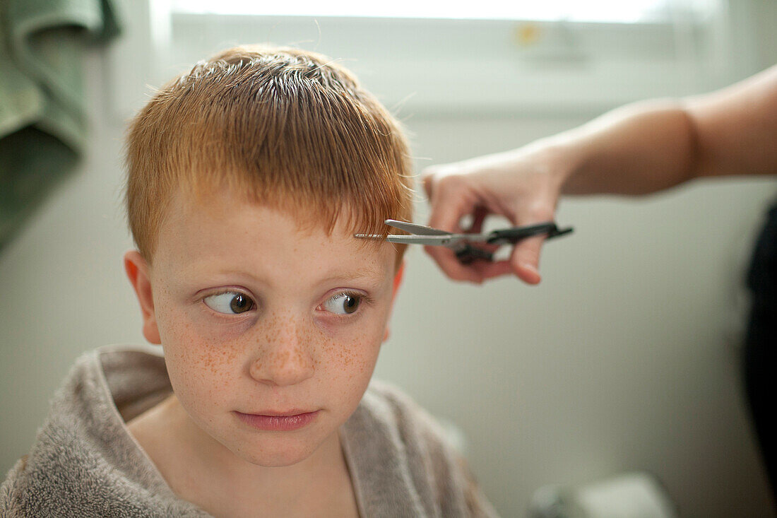 Caucasian mother giving son haircut, Blacksburg, Virginia, United States