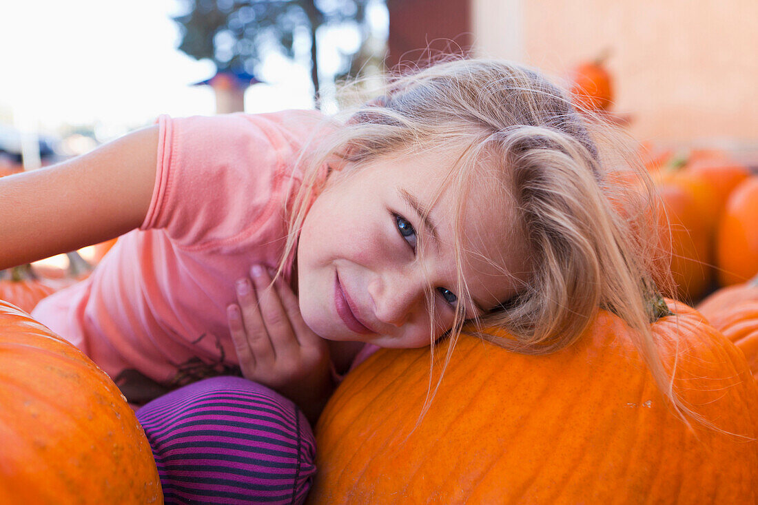 Caucasian girl sitting with pumpkins, Santa Fe, New Mexico, USA