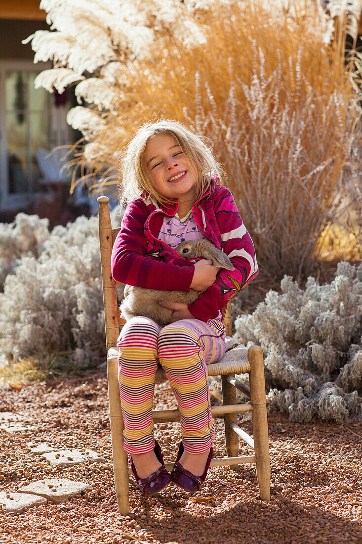 Caucasian girl smiling in chair outdoors, Santa Fe, New Mexico, USA