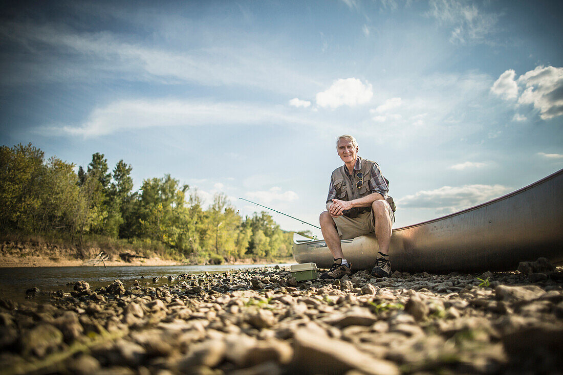 Older Caucasian man sitting in canoe on riverbed, Saint Louis, Missouri, USA