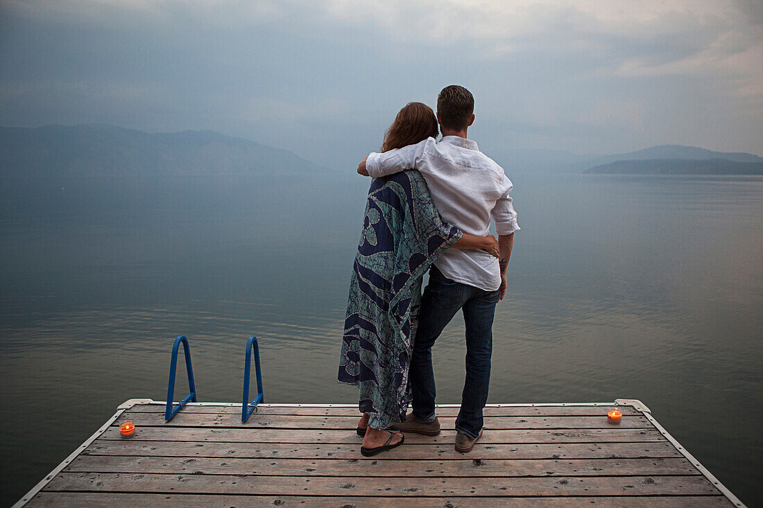 Caucasian couple standing on wooden dock over lake, Hope, Idaho, USA