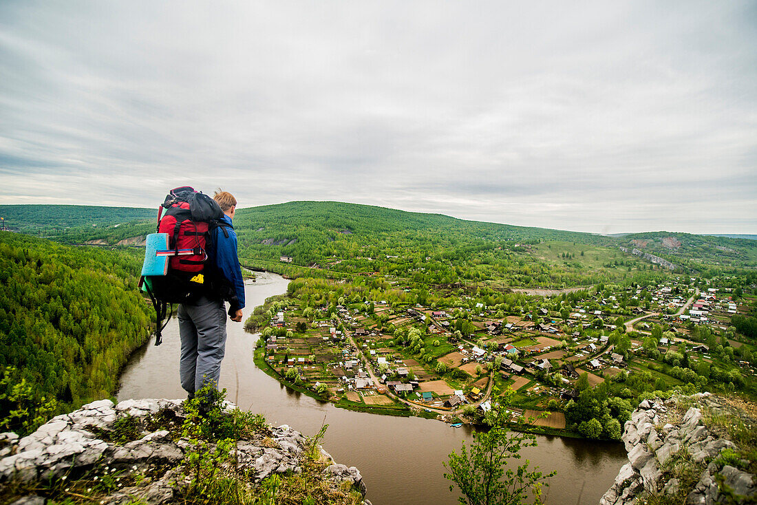 Caucasian hiker admiring scenic view of village, Perm, Ural, Russia