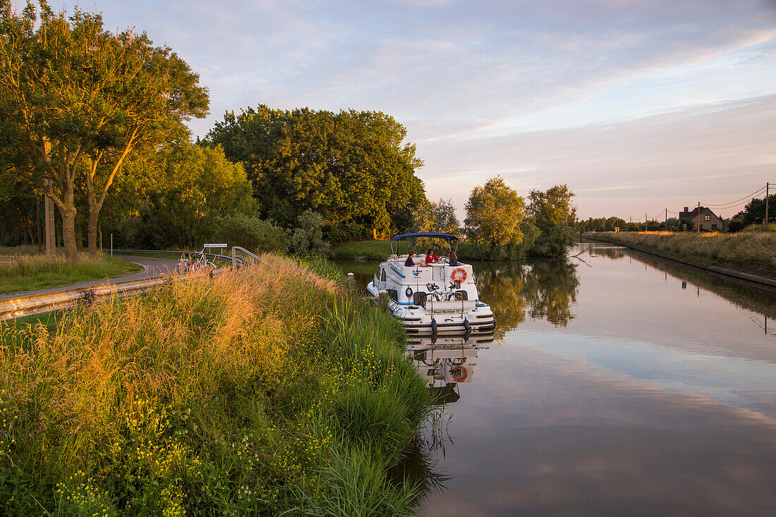 Le Boat Royal Mystique houseboat near the Knokkebrug drawbridge on the IJzer (Yser) river at sunset, near Diksmuide, Flemish Region, Belgium