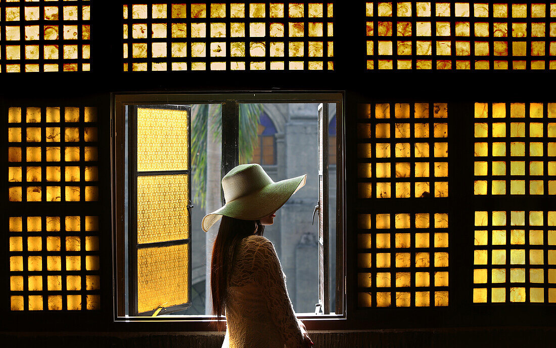 Frau steht am Fenster, Capiz Fenster, Kirche San Agustin, Intramuros, Manila, Philippinen, Asien
