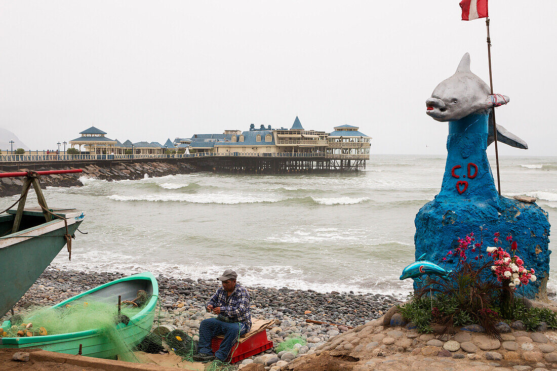 fisherman at the coast, restaurant La Rosa Nautica in the background, Lima Peru, South America