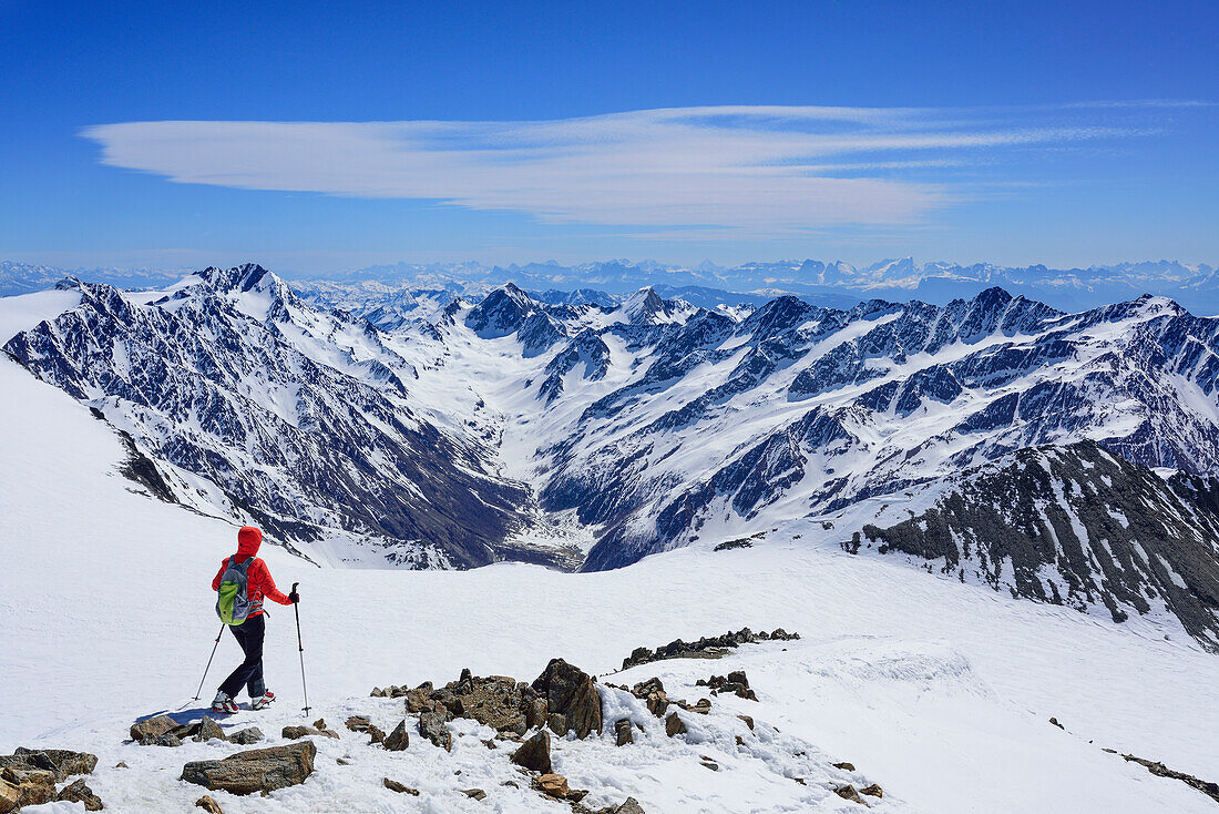 Woman back-country skiing descending Similaun, Texel range and Dolomites in background, Similaun, valley of Pfossental, valley of Schnalstal, Vinschgau, Oetztal Alps, South Tyrol, Italy