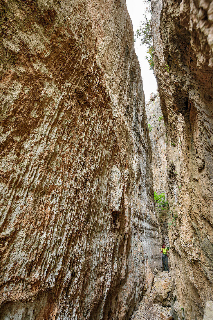 Woman hiking Selvaggio Blu through narrow canyon, Selvaggio Blu, National Park of the Bay of Orosei and Gennargentu, Sardinia, Italy