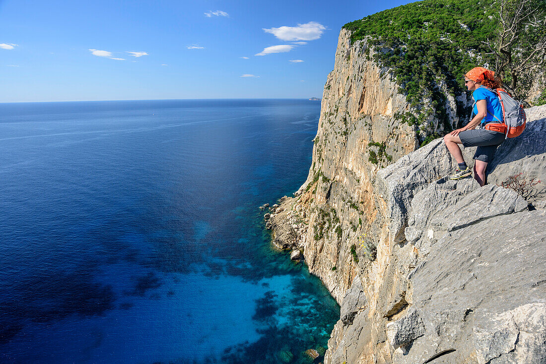 Frau beim Wandern blickt über Steilküste auf Golfo di Orosei, Selvaggio Blu, Nationalpark Golfo di Orosei e del Gennargentu, Sardinien, Italien