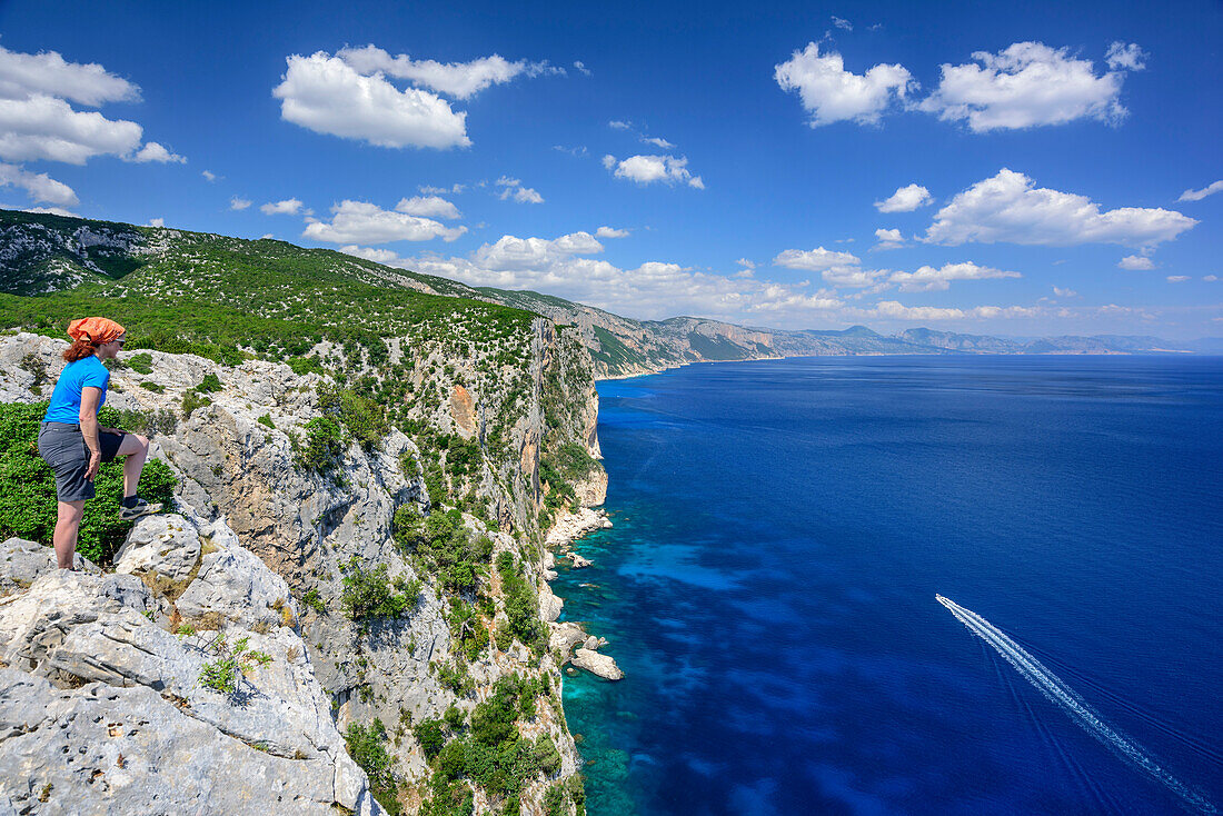 Frau beim Wandern blickt über Steilküste auf Golfo di Orosei, Selvaggio Blu, Nationalpark Golfo di Orosei e del Gennargentu, Sardinien, Italien