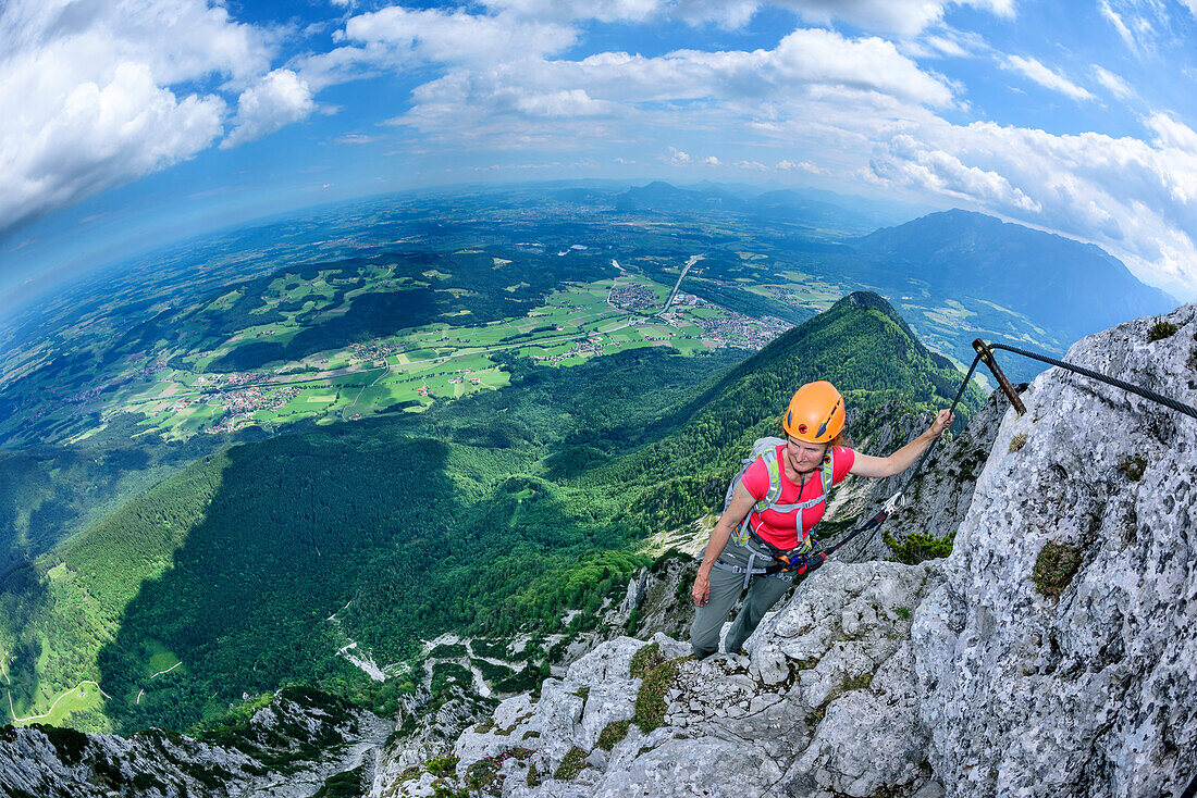 Woman ascending on steep fixed rope route, fixed rope route Pidinger Klettersteig, Hochstaufen, Chiemgau Alps, Chiemgau, Upper Bavaria, Bavaria, Germany