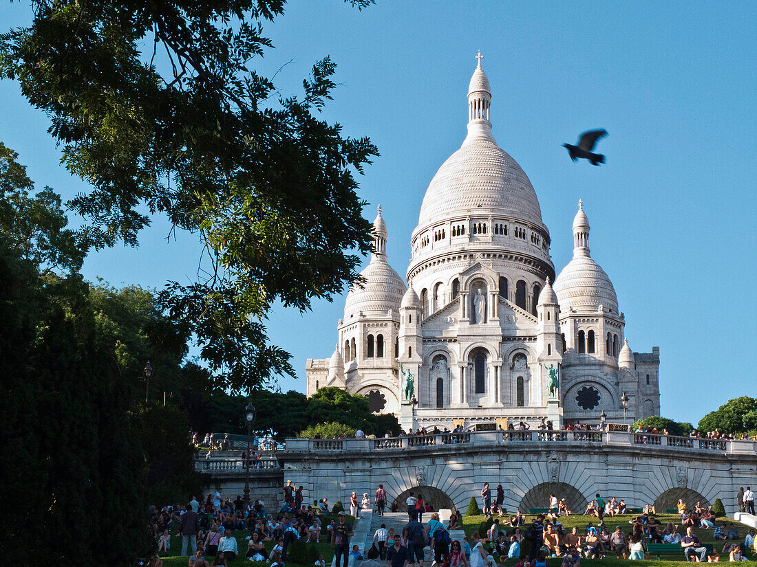 France, Paris, Montmartre, Sacré coeur basilica garden, tourists sitting on the grass, night