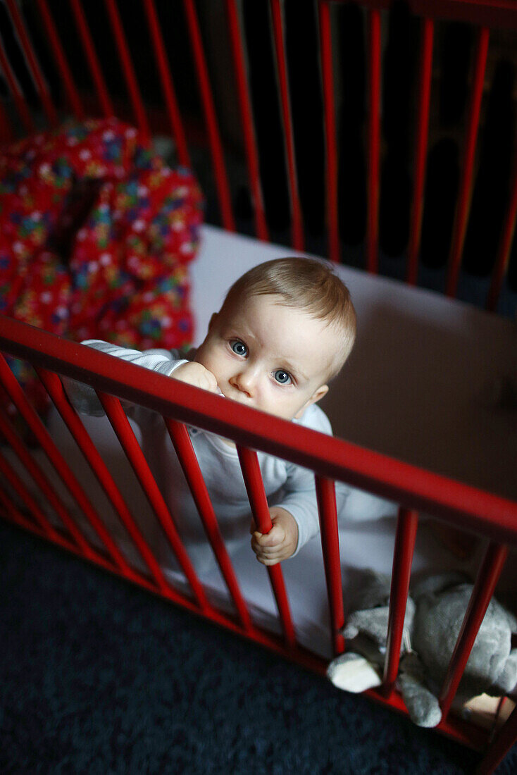 A 10 months baby boy in his baby's cot