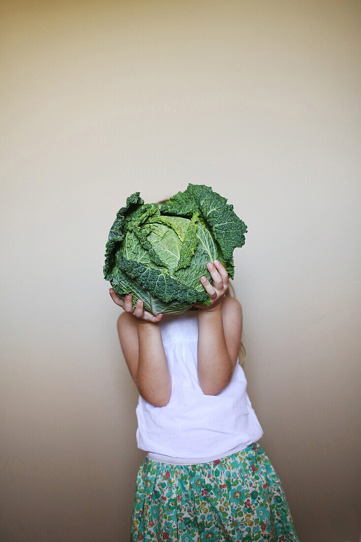 Little girl playing with a cabbage
