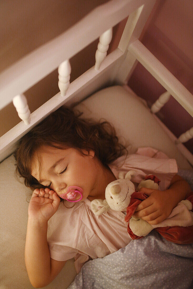 A 4 years old girl sleeping in her bed