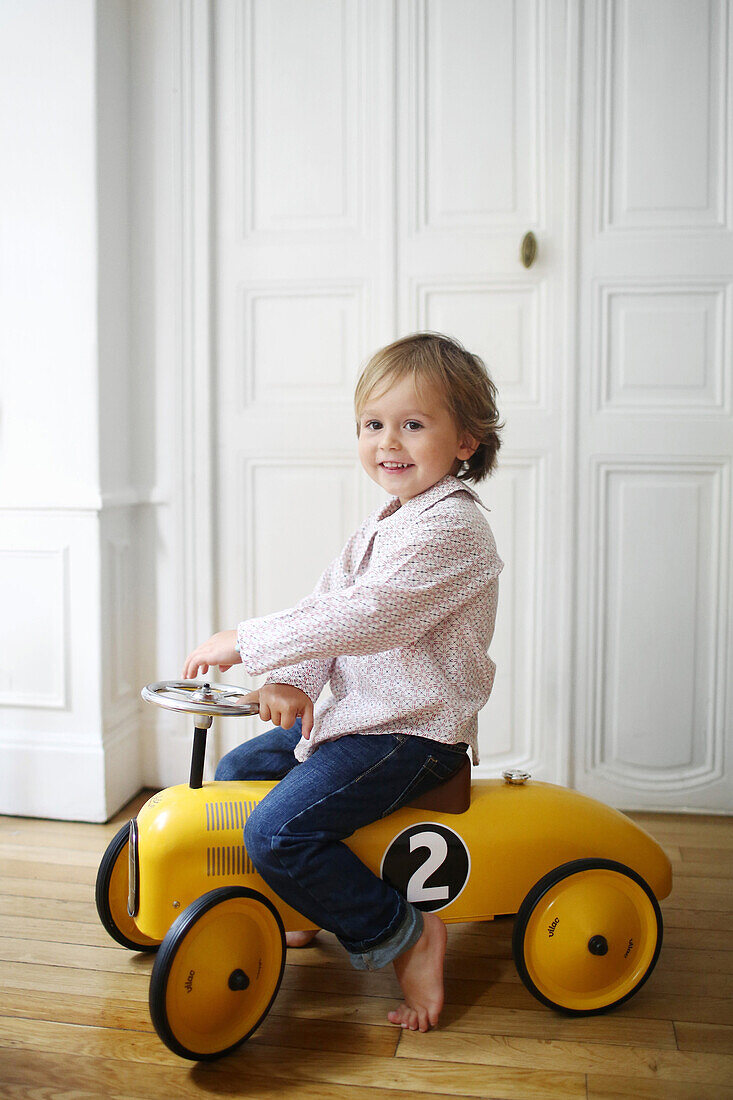 Little boy on a yellow toy car