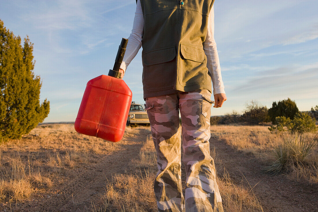 Hispanic woman carrying gas can