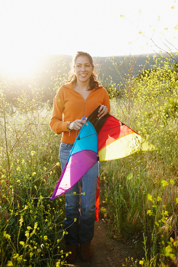 Hispanic woman holding kite outdoors