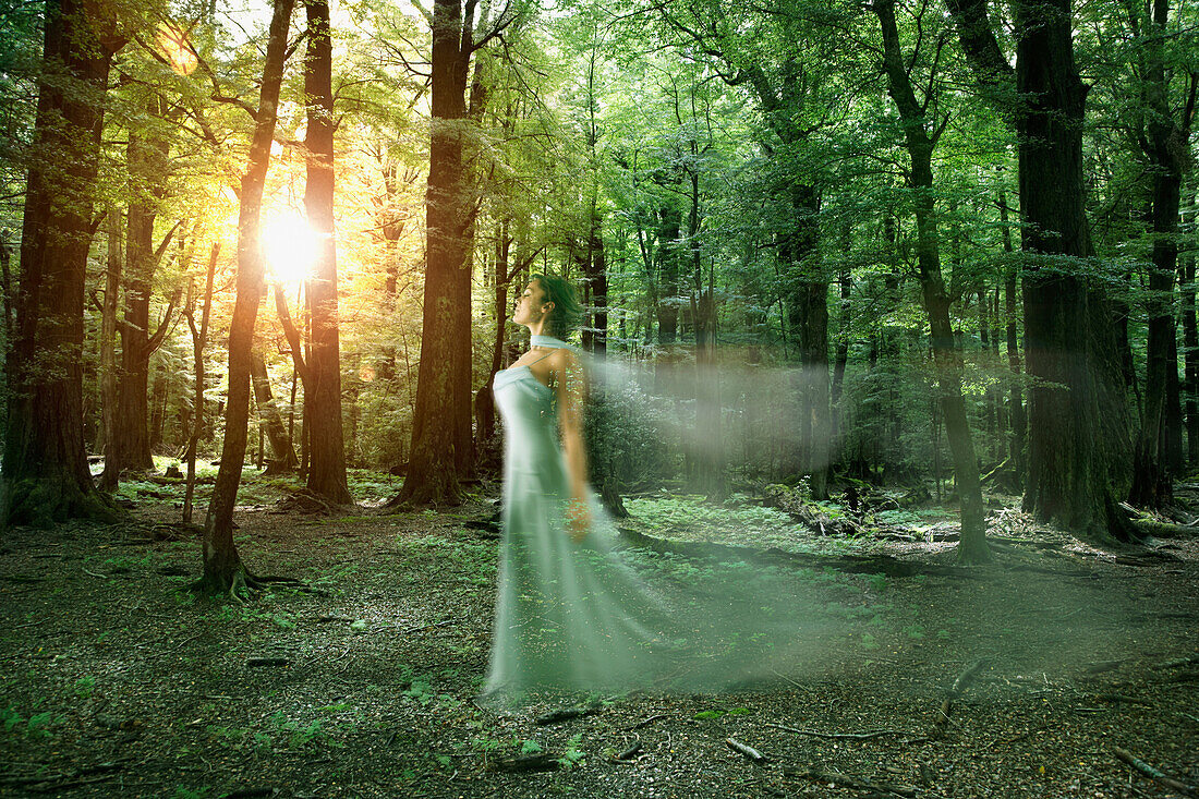 Blurred motion of elegant Hispanic woman in forest