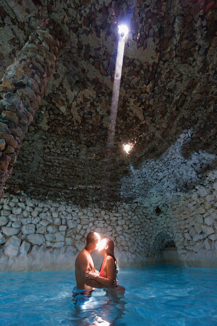 Hispanic couple kissing in swimming pool