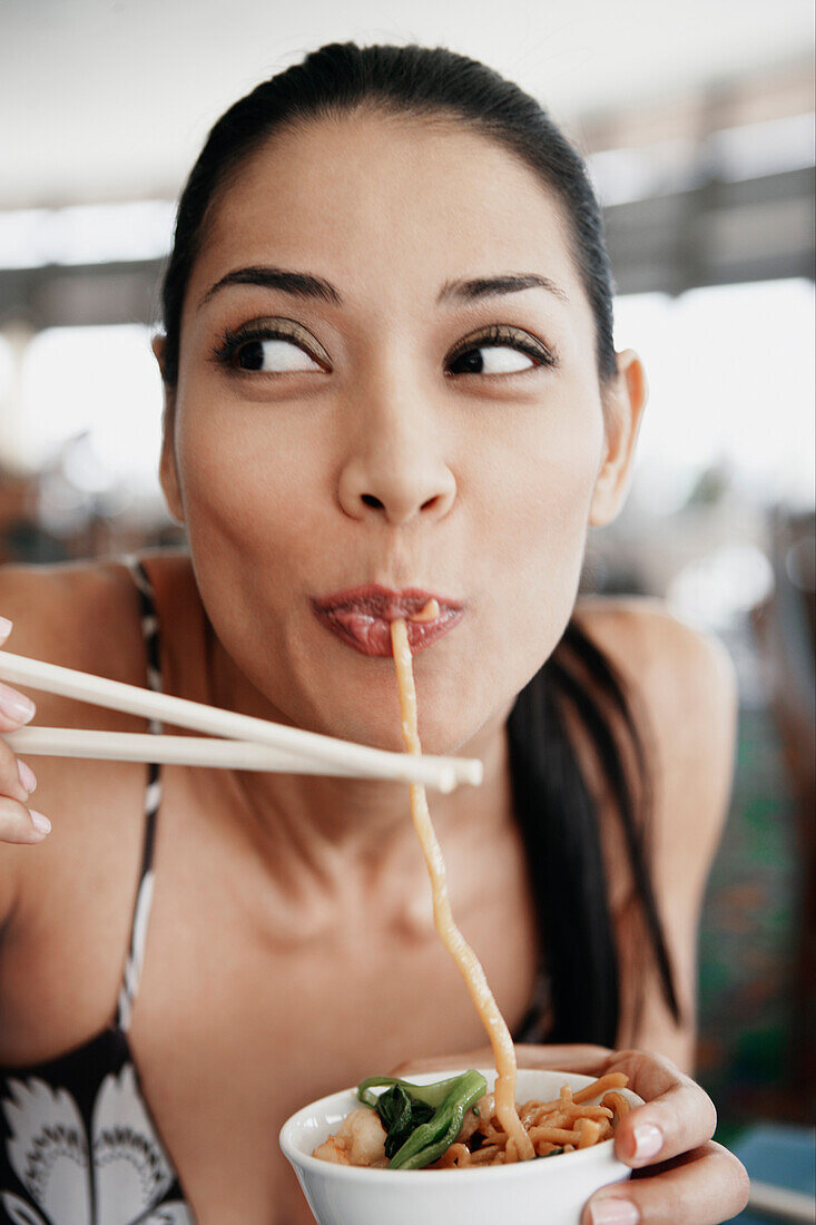 Pilipino woman eating noodles